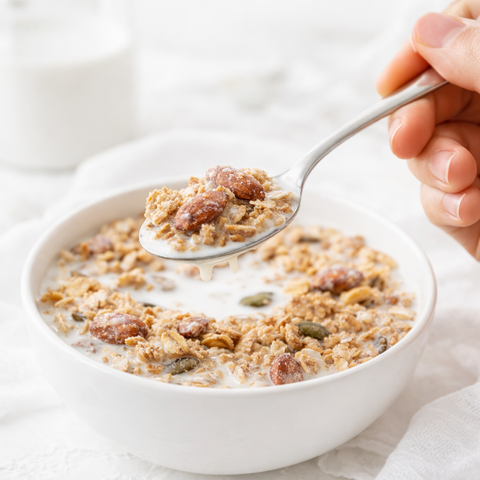 Ciotola per colazione proteica con mandorle biologiche, granola, frutta fresca e bevanda vegetale alla mandorla
