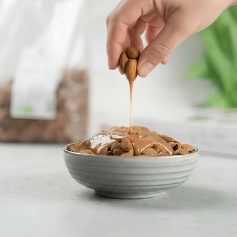 Crema di mandorla in ciotola con mandorle di Toritto su tavolo in legno