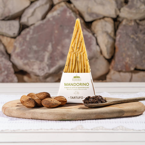 Stagionato vegetale alla mandorla al tartufo servito a scaglie su tagliere con pane tostato e verdure