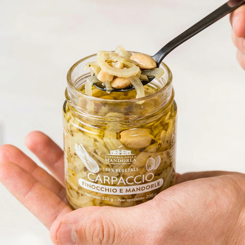 CARPACCIO DI FINOCCHIO E MANDORLA BIO - 310g — vasetto aperto in mano con cucchiaio
