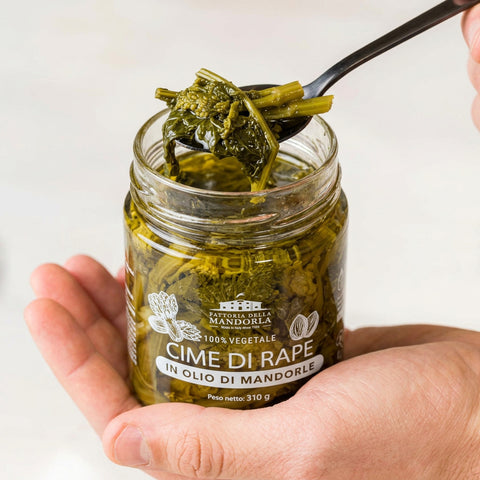 CIME DI RAPA IN OLIO DI MANDORLA BIO - 310g — vasetto aperto in mano con cucchiaio